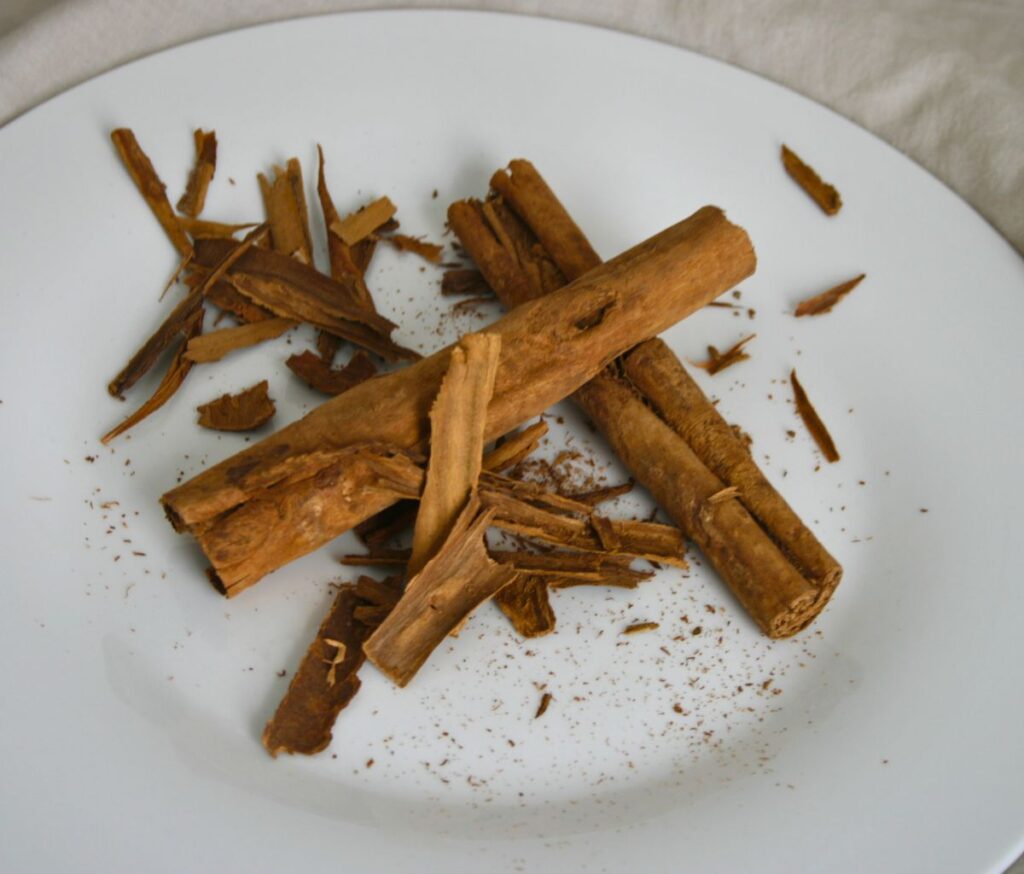 Ceylon Cinnamon sticks on white plate with beige background