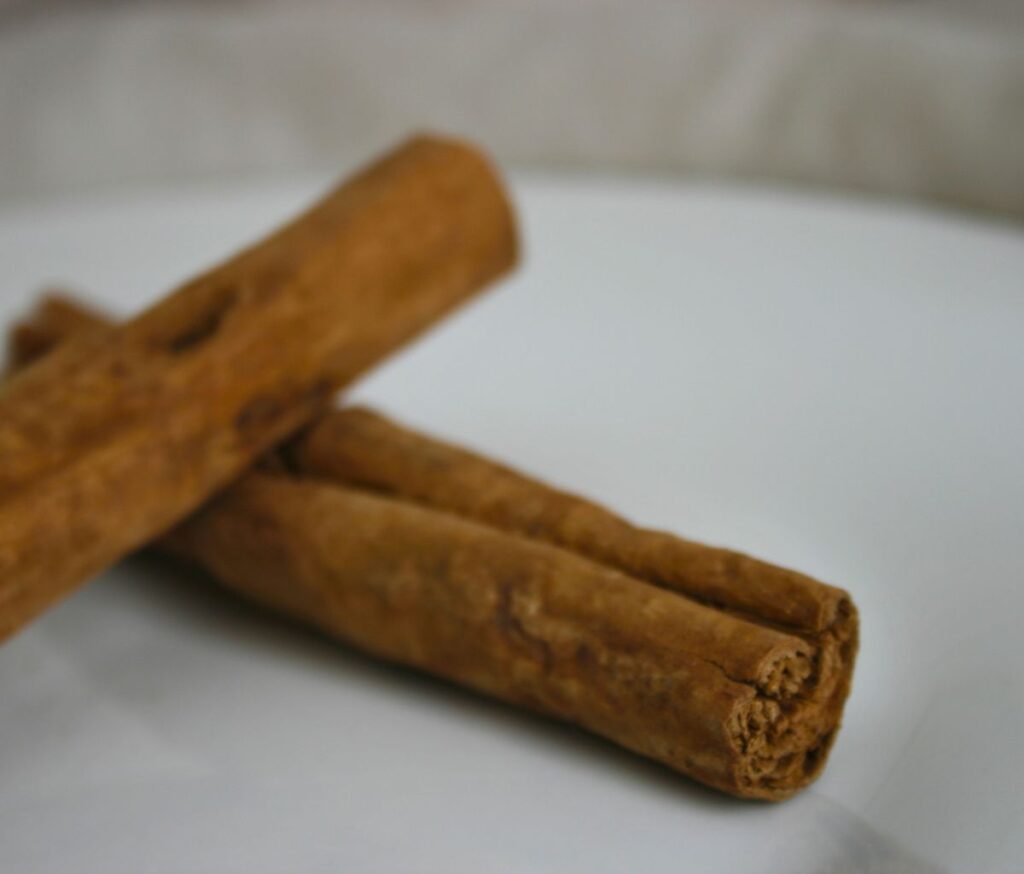 Ceylon Cinnamon sticks on white plate with beige background